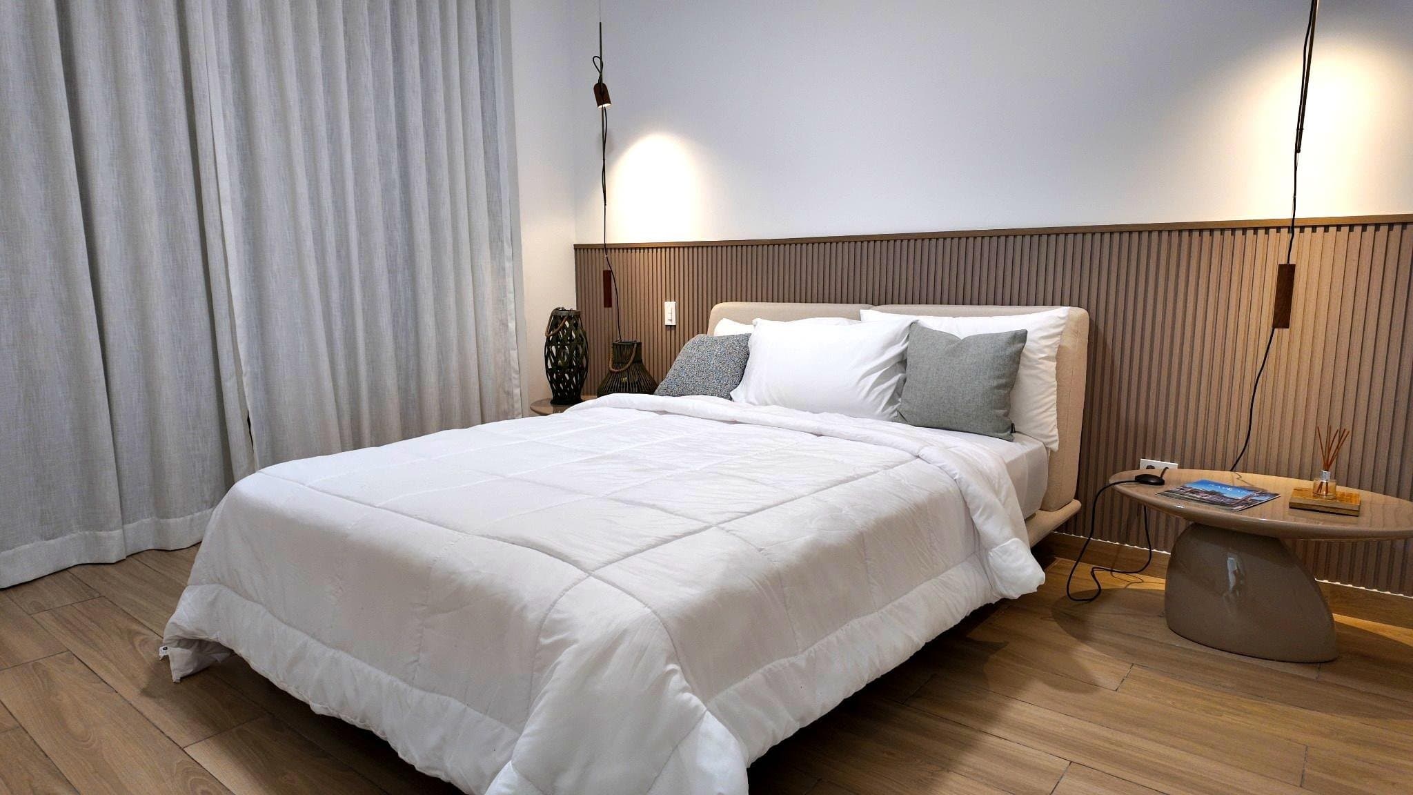 Principal bedroom with upholstered headboard and timber panelling